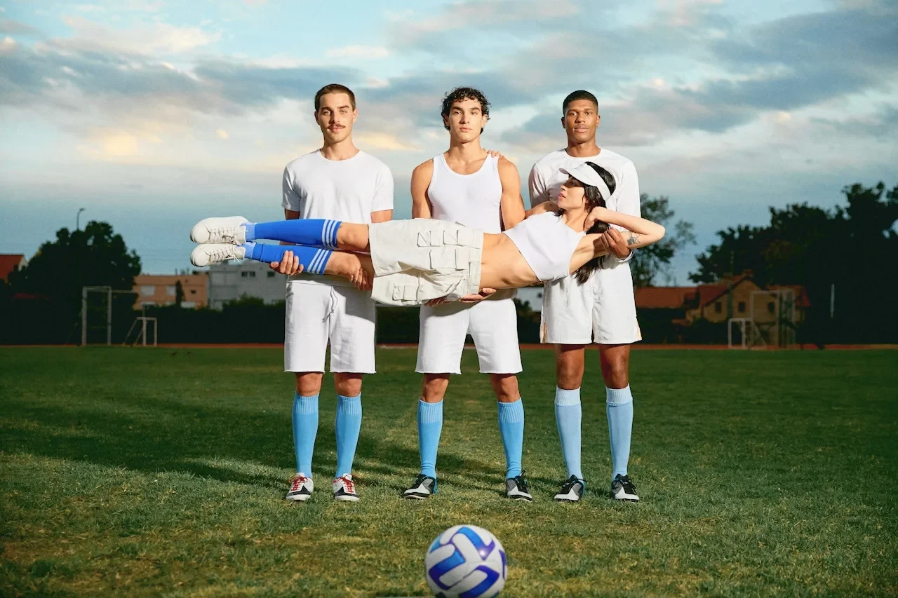 Four Pulseheaven members on a pitch at dusk